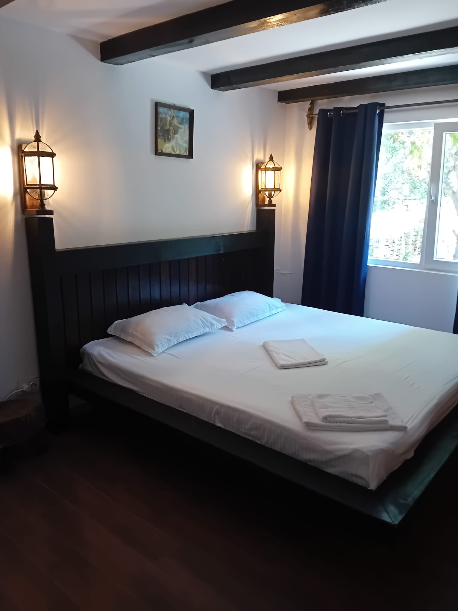 Bedroom with dark headboard and warm lantern lights at Magic Garden