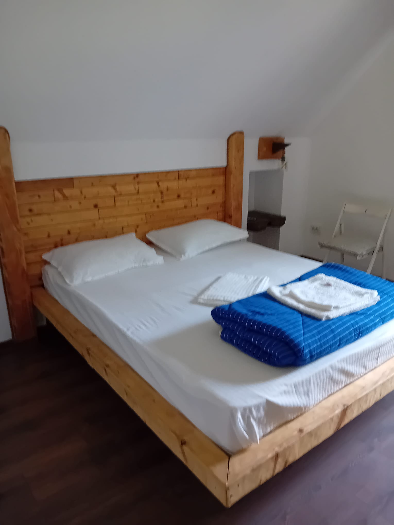 Cosy bedroom with light wood headboard and colorful rug at Magic Garden